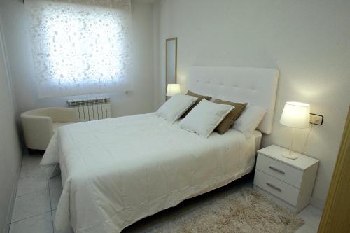 莫利诺斯德杜埃罗Apartamento junto al Duero en la Sierra de Urbión的白色卧室配有白色的床和椅子