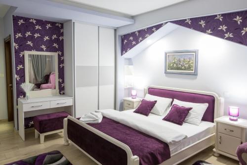 尼克希奇Apartmani MG的一间卧室设有一张大床和紫色的墙壁