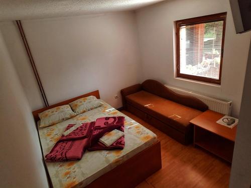 兹拉蒂博尔Guesthouse Ramović的一间带床和沙发的小卧室