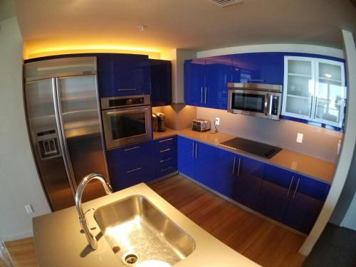劳德代尔堡2 BR W Residences Ft. Lauderdale的厨房配有蓝色橱柜和不锈钢冰箱