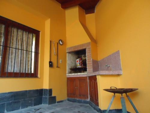 萨尔塔Casa en B° Tres Cerritos, Salta Capital. Alquiler Temporal的一间设有黄色墙壁、柜台和凳子的房间
