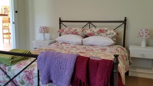 GroveThe Manager's Cottage的一间卧室配有一张带紫色和粉色枕头的床