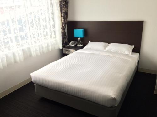 濑户内町奄美里贝斯特酒店的卧室设有一张白色大床和一扇窗户。