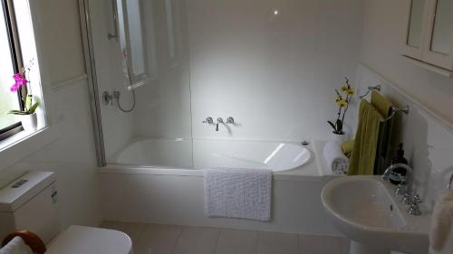 GroveThe Manager's Cottage的白色的浴室设有浴缸和水槽。
