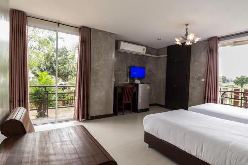 坤西育府纳瓦度假酒店的一间卧室配有一张床和一张书桌及电视