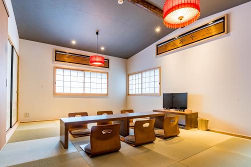 大阪Bijou Suites Nagomi的配有桌椅和电视的客房