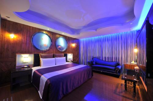 新竹新竹-紫晶彩绘汽车旅馆的一间卧室设有一张大床和蓝色的天花板