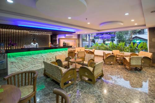日惹日惹普里萨龙酒店的一间带桌椅的餐厅和一间酒吧