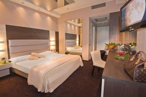 切萨诺马代尔诺戴久维AS酒店的酒店客房设有一张大床和一台电视。