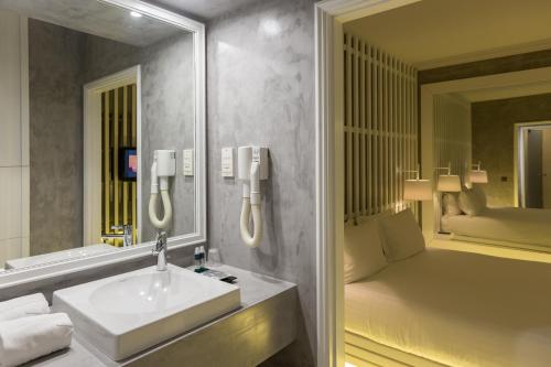 加亚新城特洛皮卡纳汽车旅馆的一间带水槽和镜子的浴室以及一张床