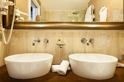 米兰米兰斯伽拉酒店的一间带大型白色浴缸和镜子的浴室