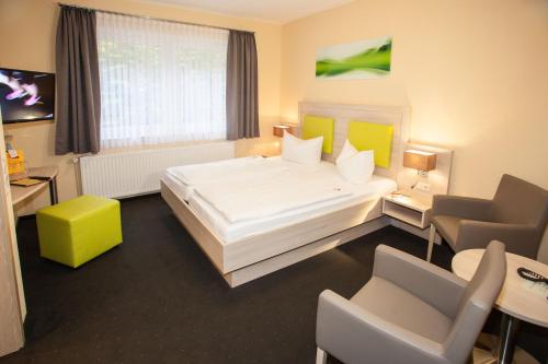 兰格尔斯海姆因姆坦奈格鲁德酒店的酒店客房带一张大床和椅子