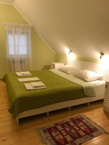彼得宫城New House的一间卧室配有一张带绿毯的大床