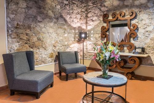 瓜纳华托卡萨维瑞耶斯酒店的一间设有两把椅子和一束花的等候室