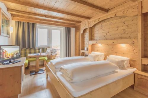 特林斯Alpen Gasthof Apartments Hohe Burg的一间卧室配有两张床和一张书桌。