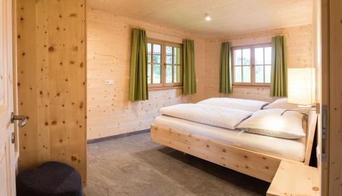 塞斯托Alpenchalets Mair的木制客房内的一间卧室,配有一张床