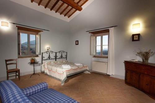 阿西西Casale Merlino的一间卧室配有一张床、一张沙发和窗户。