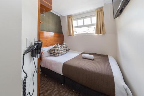 伦敦切斯特酒店的一间小卧室,配有一张床和电视