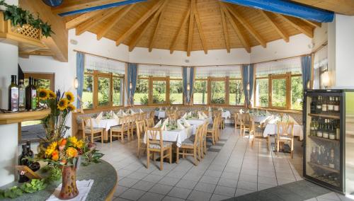 弗拉塔赫Alpenhotel Badmeister的用餐室设有桌椅和窗户。