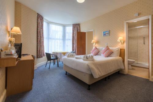 纽基艾略特酒店 的酒店客房设有一张大床和一间浴室。