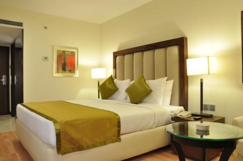 班加罗尔阿达尔斯汉密尔顿酒店的酒店客房设有一张大床和一张桌子。