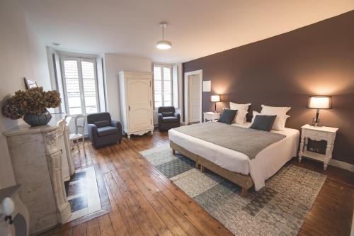 塞纳河畔诺让Le Relais de l'endormie的一间卧室配有一张大床和两把椅子