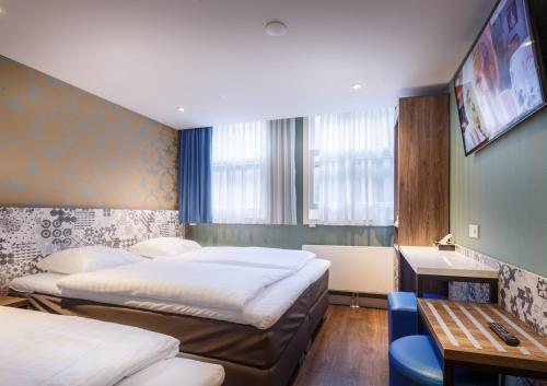 阿姆斯特丹老尼克尔酒店的酒店客房设有两张床、一张桌子和一张桌子。