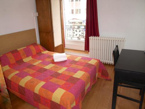 第戎夏多布里昂酒店的一间卧室配有一张床、一张桌子和一个窗户。