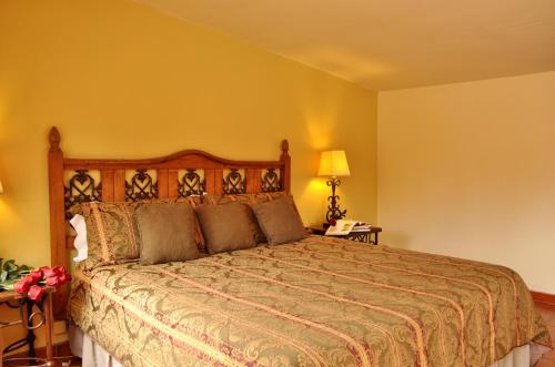 恩塞纳达港Horsepower Ranch的一间卧室设有一张床和黄色的墙壁