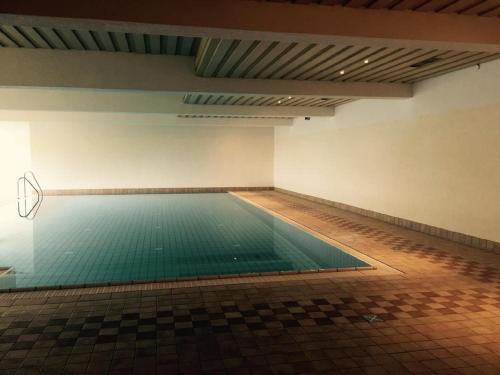 玛丽亚阿尔姆Am Berg 34的游泳池位于一间空空的房间里,铺有瓷砖地板