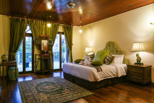 马六甲荷仁博物馆5号酒店的一间卧室设有一张床和木制天花板