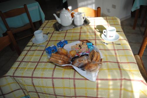 阿尔盖罗B&B ARENOSU25的一张桌子上放着一盘面包和糕点