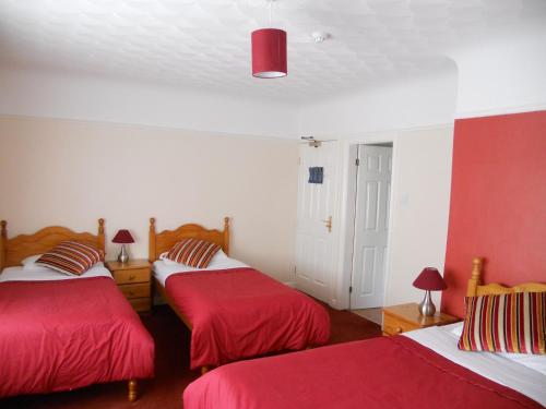 斯皮克盖特威旅舍的红色和白色的客房内的两张床