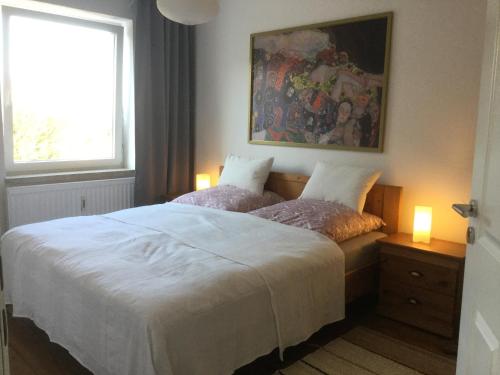 吕贝克Grö 13的卧室配有带两盏灯的白色床
