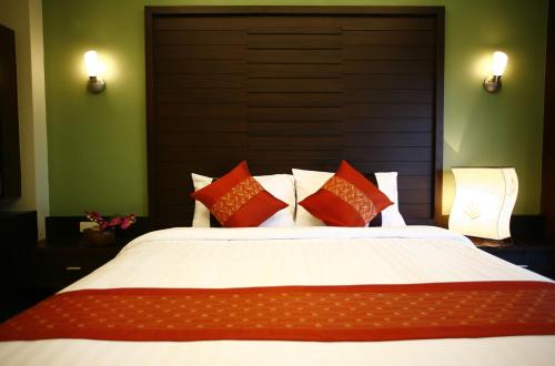 拉迈Lamoon Lamai Residence & Guesthouse的一间卧室配有一张带红色和白色枕头的大床