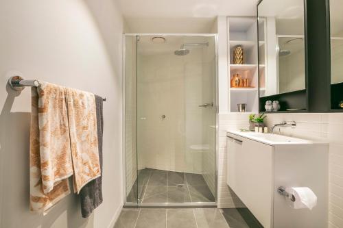 墨尔本奎斯特弗莱明顿中心公寓式酒店的一间带玻璃淋浴和水槽的浴室