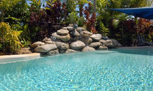 米申海滩使命珊瑚礁度假酒店的庭院内一个带岩石墙的游泳池