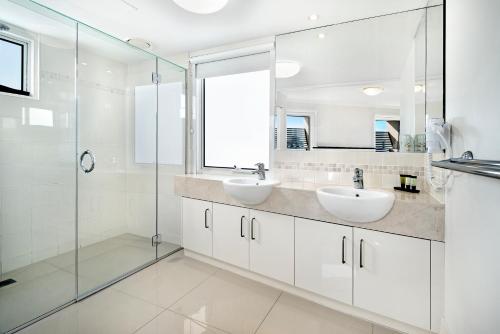 卡伦德拉乌尔提卡海鸥度假酒店的一间带两个水槽和玻璃淋浴间的浴室