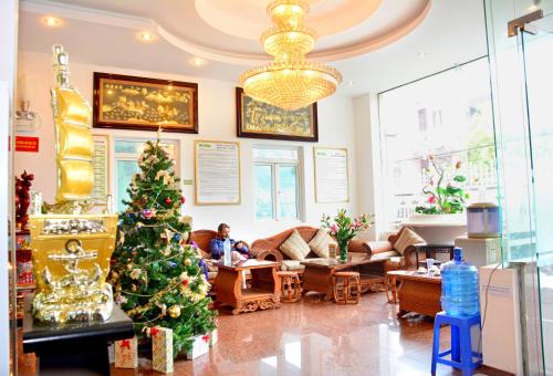 岘港A25 Hotel -137 Nguyễn Du - Đà Nẵng的和女人在一起的客厅里的圣诞树