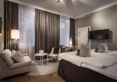 乌普萨拉安娜别墅酒店的酒店客房带一张大床和一把椅子