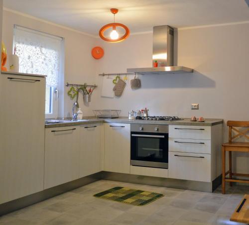 韦尔巴尼亚Casina dello Zio的厨房配有白色橱柜和炉灶烤箱。