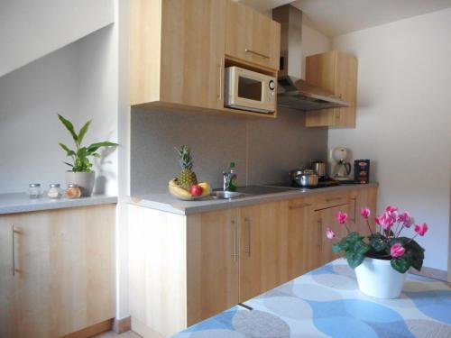 瓦尔道拉Residence Hofer的厨房配有木制橱柜和鲜花桌