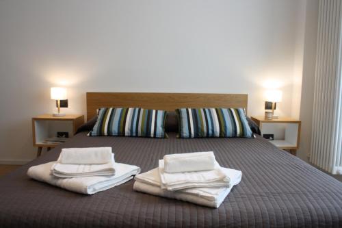 米兰米兰纳威格力公寓 - 托尔托纳大街的一间卧室配有带毛巾的床