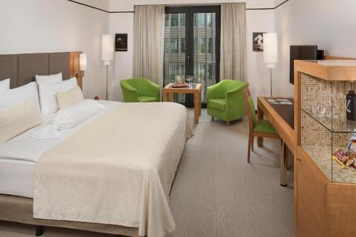 柏林柏林美利亚酒店的酒店客房带一张床、一张桌子和椅子