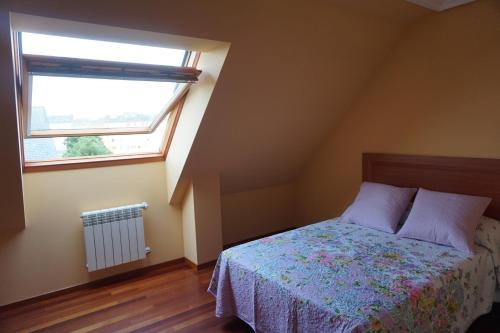 里瓦德奥Duplex Ribadeo的一间卧室设有一张床和一个窗口