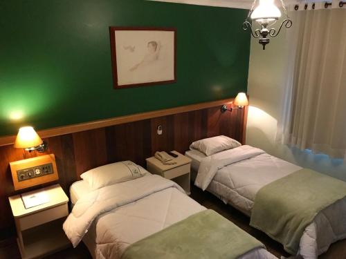 圣保罗Residencial Pantanal Vila Mariana的一间设有两张床和绿色墙壁的客房