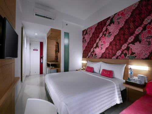 日惹日惹马里奥波罗酒店的卧室配有一张白色大床和红色墙壁