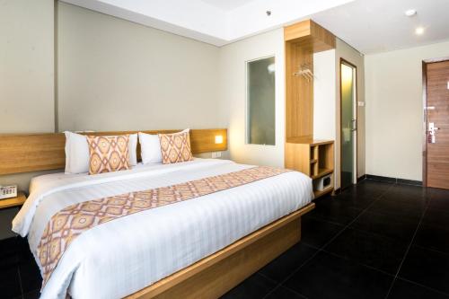 雅加达格鲁格尔枫叶酒店 的一间卧室,卧室内配有一张大床