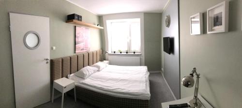 比得哥什雅盖隆公寓70号的小房间设有一张带窗户的床