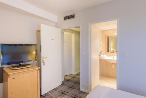 图尔美居旅游中心会议中心酒店的客房设有电视和浴室。